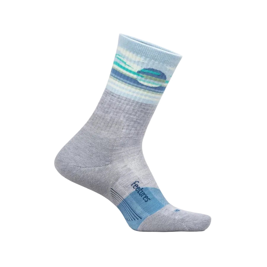 A single sock shown on a foot form against a light beige background. The sock is heather gray with a blue and teal wave pattern near the cuff and a light blue toe section featuring the 'feetures' brand name.