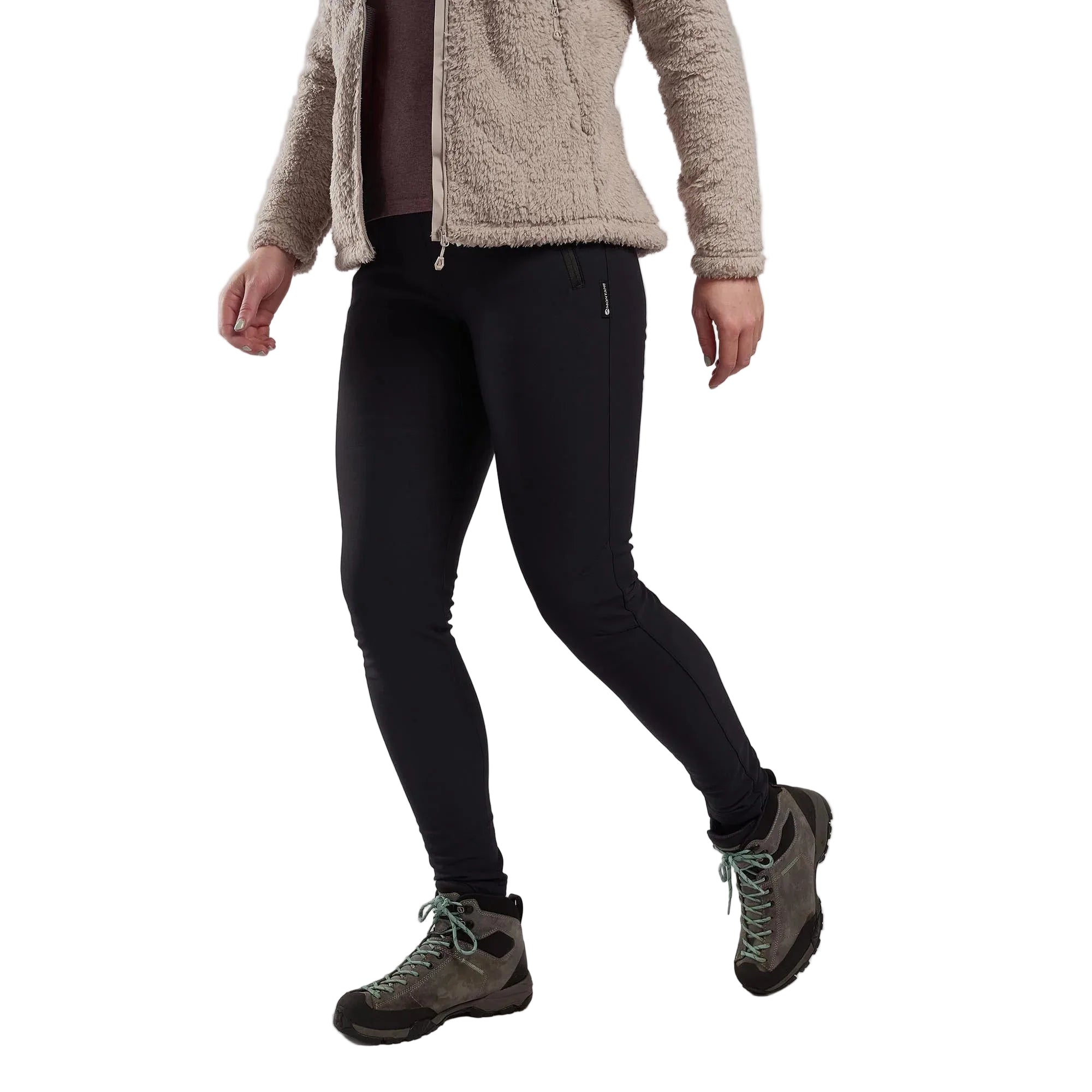 Person wearing black leggings, beige fleece jacket, and hiking boots on a plain background