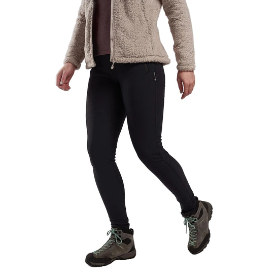 Person wearing black leggings, beige fleece jacket, and hiking boots on a plain background