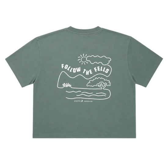 A sage green short-sleeve t-shirt shown from the back, featuring a white line art graphic of a landscape with the text 'FOLLOW THE FEELS' and a small 'George Fisher' brand logo printed below.