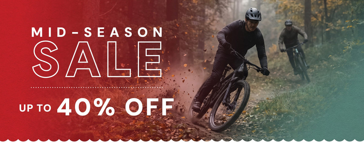Mountain bikers riding a forest trail during a mid-season cycling sale, with promotional text highlighting discounts of up to 40% off.