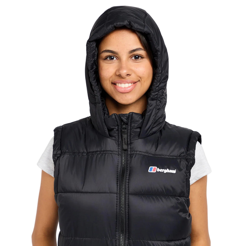 Person wearing a black puffer vest with a brand logo on a white background