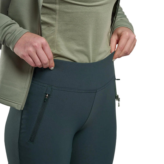 Person wearing green top and dark green pants with a white background