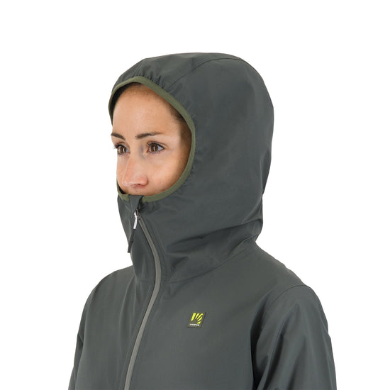 Person wearing a green hooded jacket with a visible brand logo on a white background