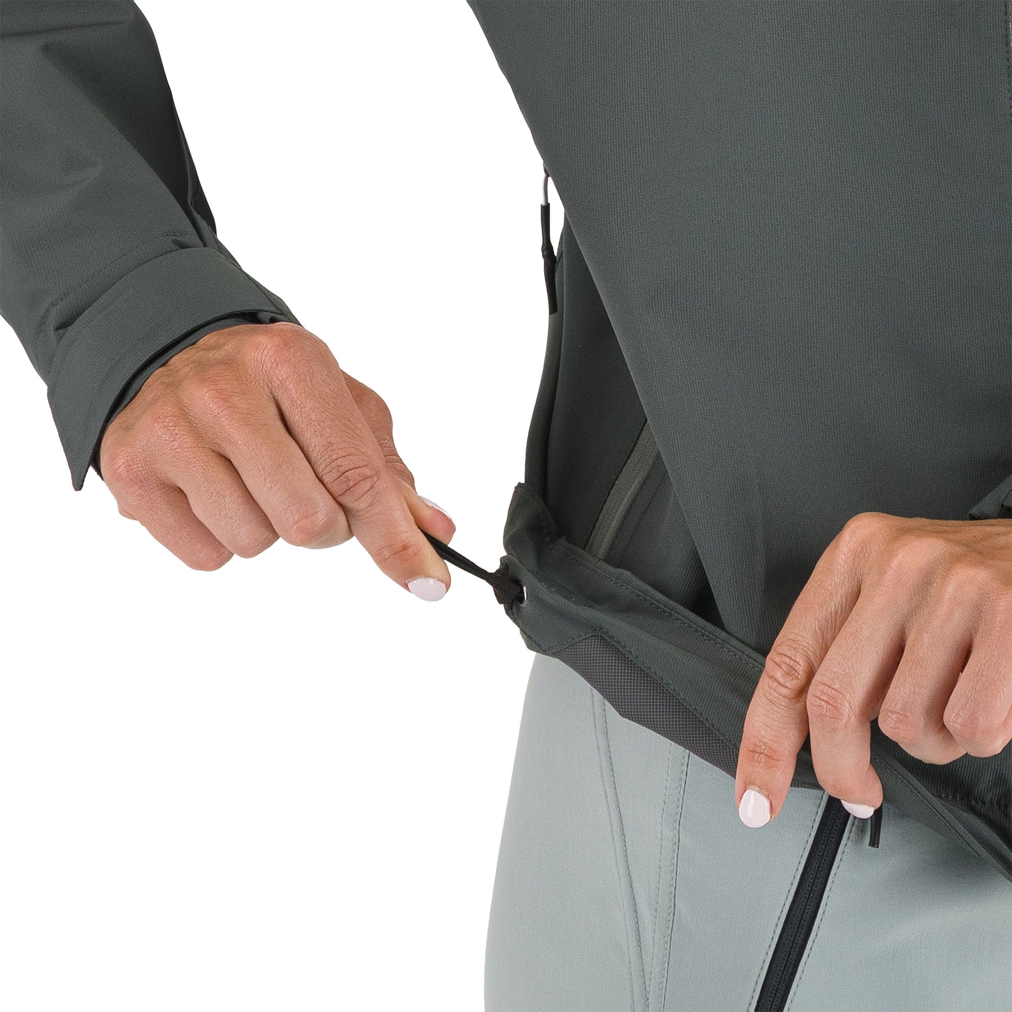 Person adjusting a zipper on a gray jacket against a white background