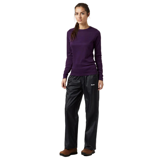 Woman wearing a purple long-sleeve shirt and black pants on a white background