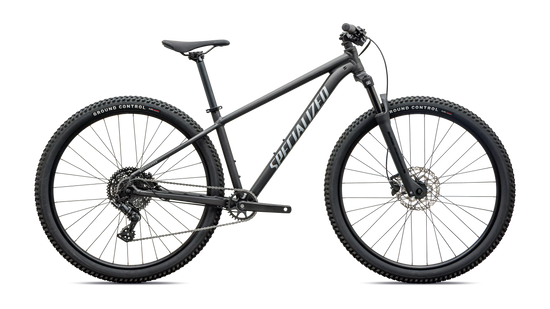Side profile of a grey front suspension mountain bike on a white background 