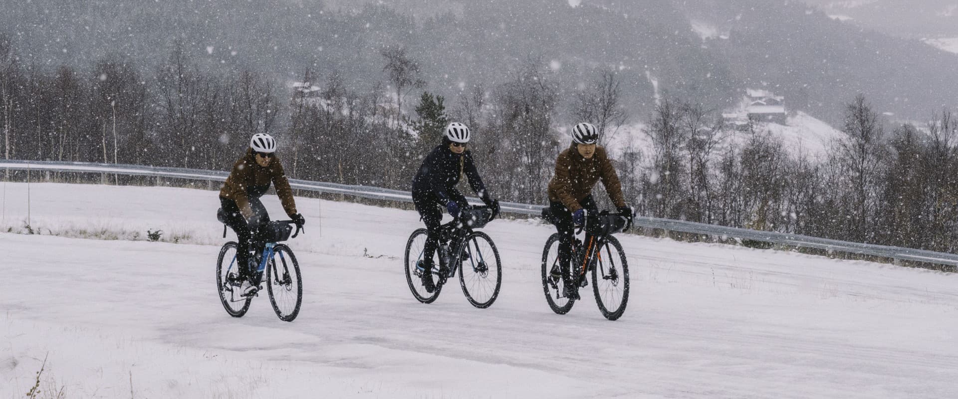 Header image. Three cyclists on snowy road.